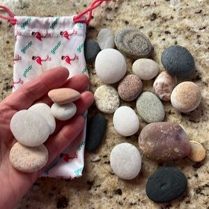 Small sack, full of pretty beach, rocks, white, black pink and brown smooth flat